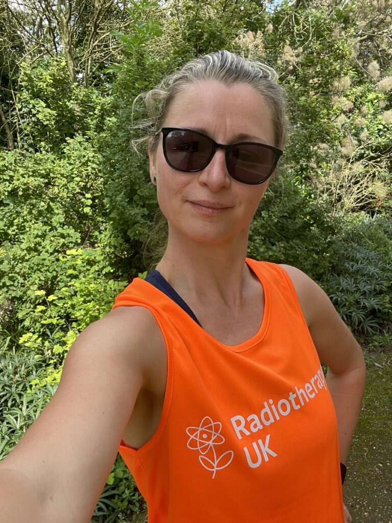 Katy wears her #MIles4Radiotherapy vest and sunglasses - the vest is bright orange