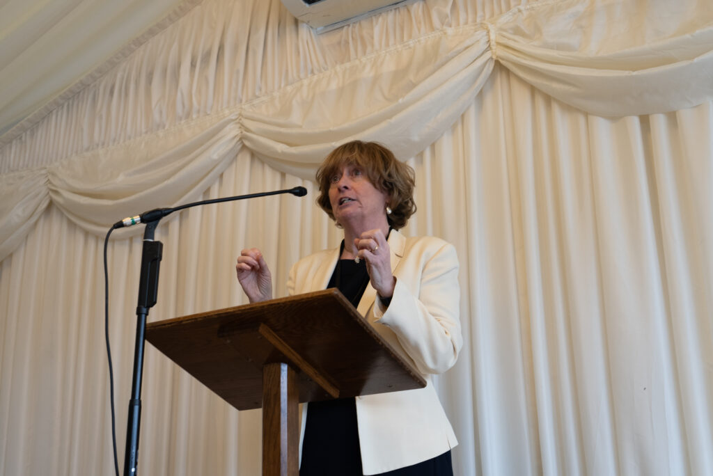 Professor Pat Price speaks at the launch of a 10-year Vision for Radiotherapy, wearing a black top and white jacket